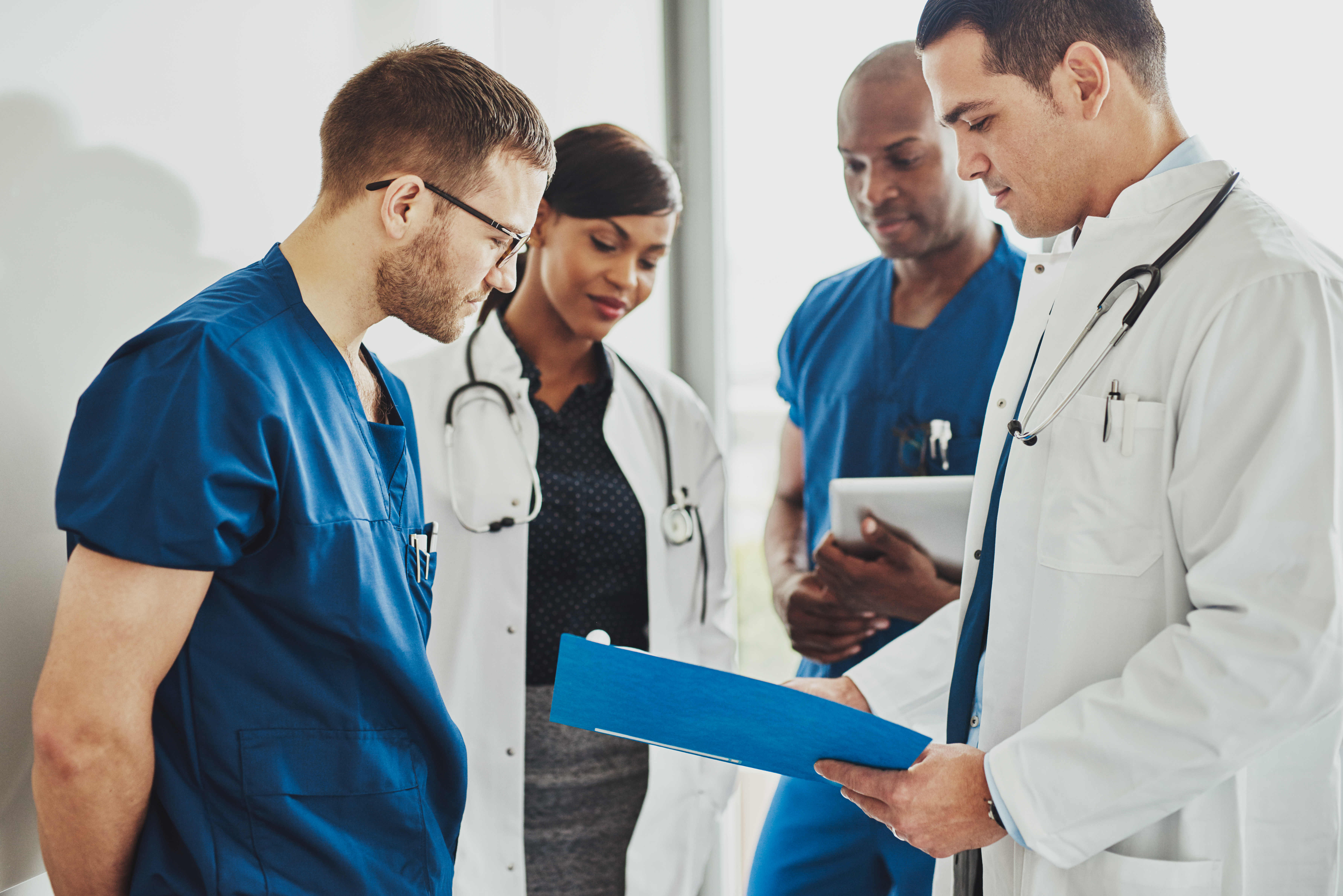 a group of doctors poring over documents regarding loans for doctors and discussing them with commitment