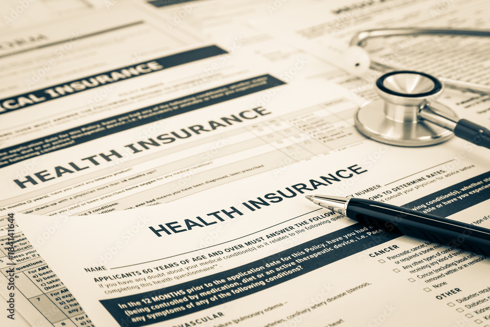 Health insurance forms on a desk with a stethoscope and pen, symbolizing medical and insurance documentation.