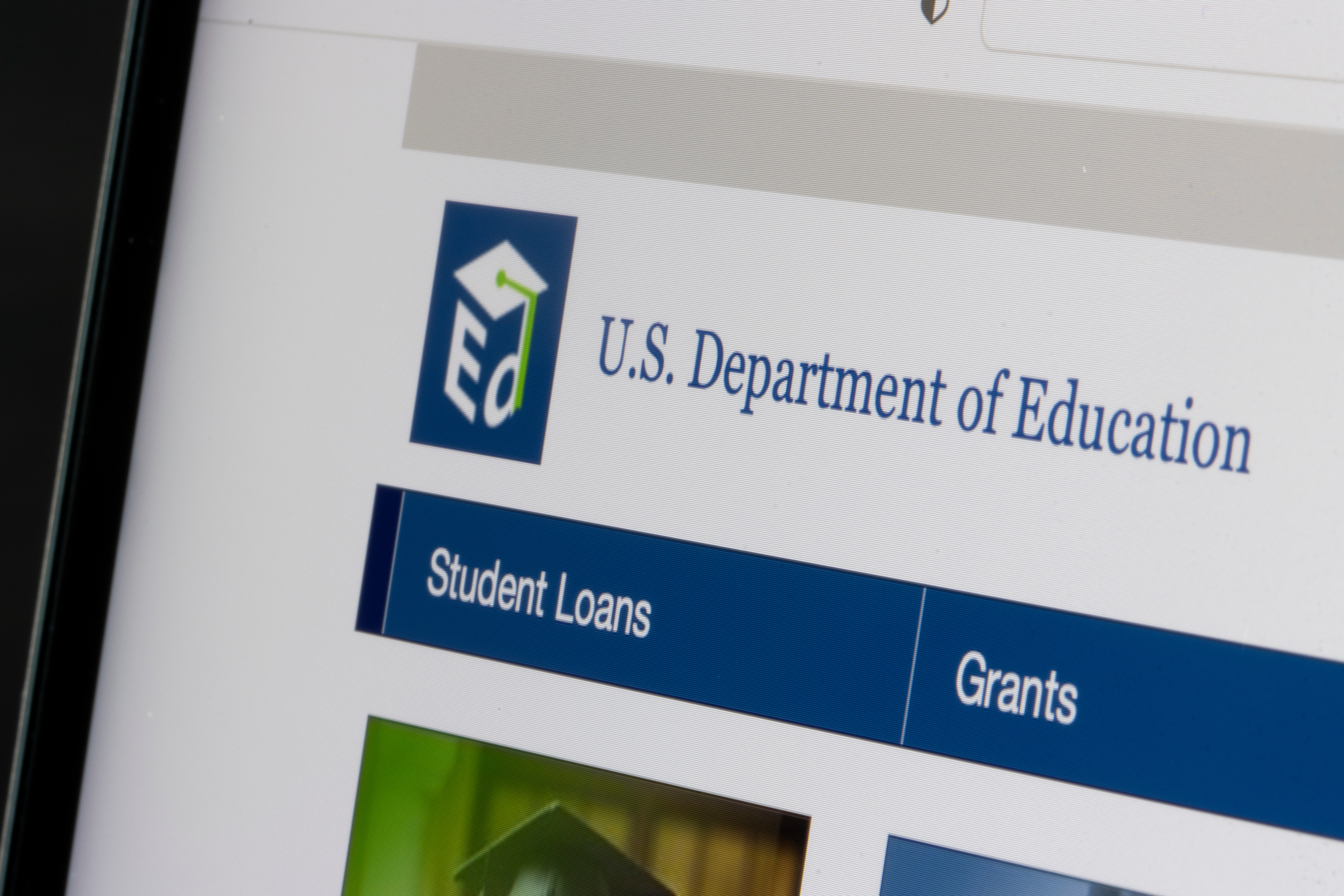 Close-up view of the U.S. Department of Education website interface, highlighting sections for student loans and grants.